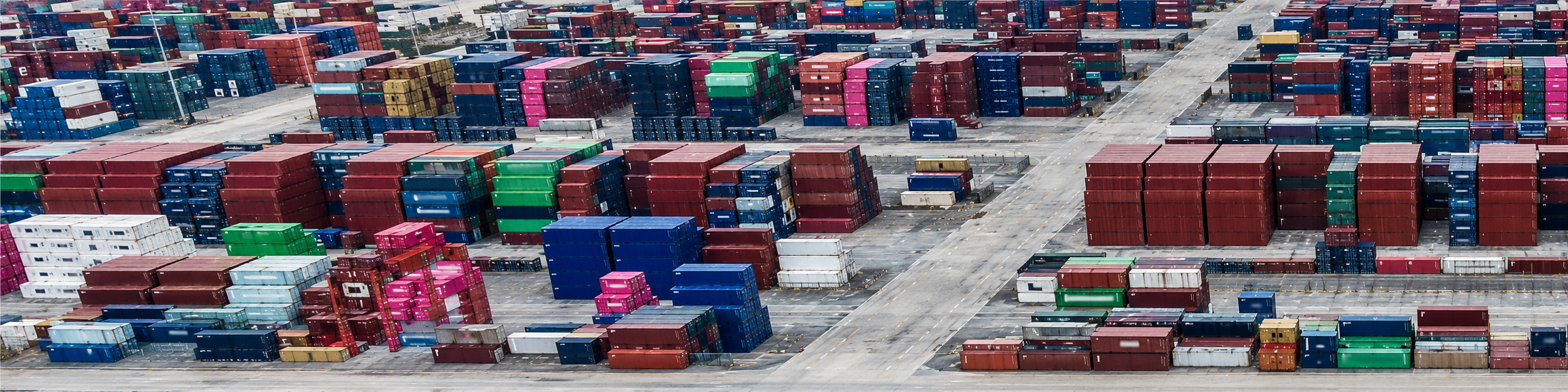 Aerial view of colorful shipping containers in an industrial yard, representing international logistics and freight coordination for OEM bag manufacturing orders.